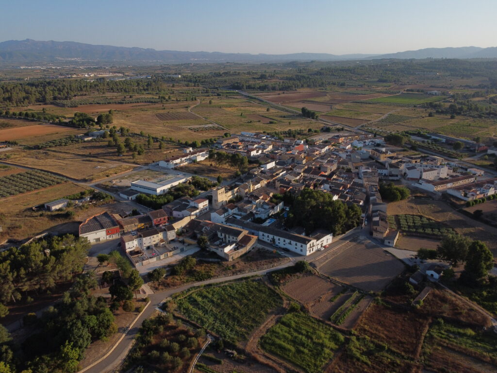 Imagen del pueblo de Bellús en vista aérea rodeado de huerta y campos de cultivo. Al hacer click se amplia la imagen.